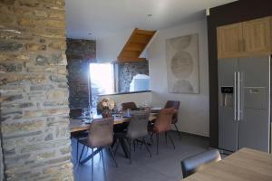 a kitchen with a dining table and a stone wall at Charming stone farmhouse in Frenet