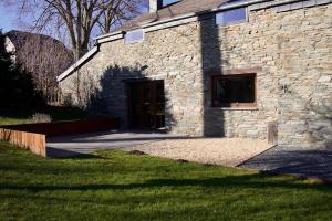 a stone building with a door in the grass at Charming stone farmhouse in Frenet