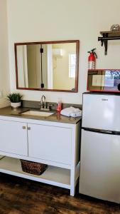 a kitchen with a sink and a mirror and a refrigerator at Bigfoot Hideout in Winslow