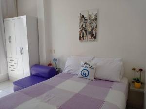 ein Schlafzimmer mit einem lila und weißen Bett mit einem Kissen in der Unterkunft Vista Mar - Studio em Copacabana a 1 min da praia e próximo ao metrô in Rio de Janeiro
