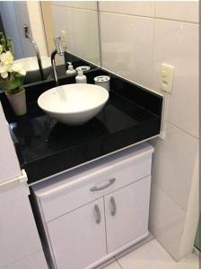 ein Badezimmer mit einem Waschbecken und einer schwarzen Theke in der Unterkunft Vista Mar - Studio em Copacabana a 1 min da praia e próximo ao metrô in Rio de Janeiro
