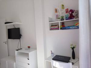 Dieses weiße Zimmer verfügt über einen Schreibtisch mit einem Laptop. in der Unterkunft Vista Mar - Studio em Copacabana a 1 min da praia e próximo ao metrô in Rio de Janeiro