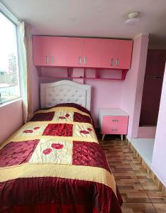 1 dormitorio con armarios rosas y 1 cama en Apartamento en El Tambo - Huancayo, en Huancayo