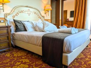 a bedroom with a large bed with white sheets and pillows at Hotel Il Gentiluomo in Arezzo