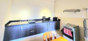 a small kitchen with a sink and a stove at Number 7, 2nd floor, Pebble Bay Apartments with Garden View in Grand Baie +9 photos