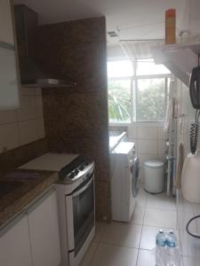 a kitchen with a sink and a stove top oven at apartamento barra da tijuca in Rio de Janeiro