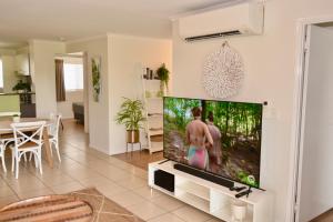 sala de estar con TV de pantalla plana grande en City Stadium Apartment on the riverfront, en Townsville