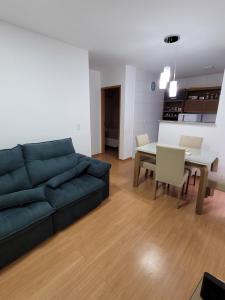 sala de estar con sofá azul y mesa en Residencial Jardim da costa, en João Pessoa