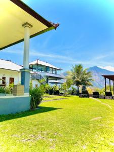 a house with a large yard with a grass field at Batur Volcano Guesthouse in Kintamani