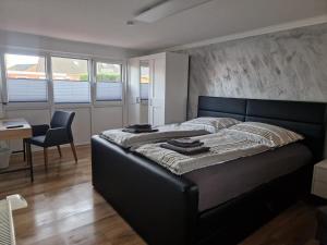 a bed in a bedroom with a desk and a chair at Ferienhaus Nordseeglück im Ferienpark Berumbur in Berumbur +51 photos