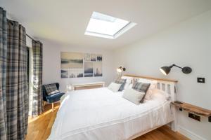 a bedroom with a white bed and a skylight at Rowanbank Cabin - a gorgeous country escape in Kirkton of Auchterhouse