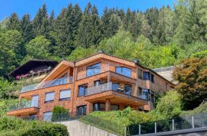 uma casa no lado de uma colina com árvores em Eagles Nest - by Alpen Apartments em Zell am See