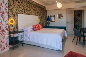 a bedroom with a bed and a table and a chair at Taormina Seaview - Luxury Apartment in Taormina in Taormina