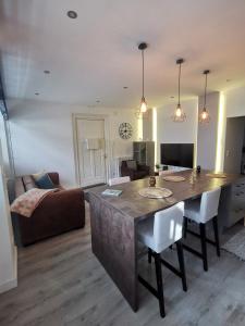 a kitchen and living room with a table and a couch at Le Petit Brooklyn, 2 chambres 2 sdb, cœur de Strasbourg in Strasbourg