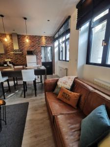 a living room with a brown couch and a table at Le petit Brooklyn in Strasbourg