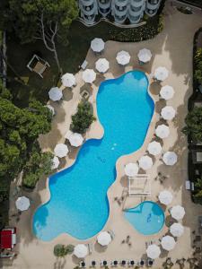 een luchtzicht op een zwembad van het resort met parasols bij Prinsotel La Pineda in Cala Ratjada