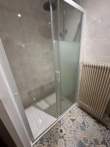 une cabine de douche avec une porte vitrée dans une salle de bain dans l'établissement La petite Semuroise, à Semur-en-Auxois 32 autres photos
