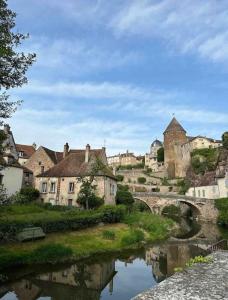 une ville avec une rivière, un pont et des bâtiments dans l'établissement La petite Semuroise, à Semur-en-Auxois