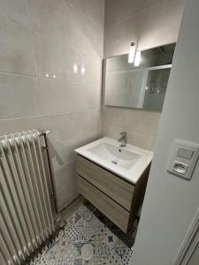 une salle de bain avec un lavabo, un miroir et un radiateur dans l'établissement La petite Semuroise, à Semur-en-Auxois