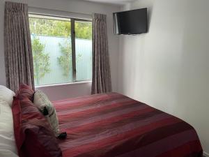 1 dormitorio con cama y ventana grande en Villa55, en Christchurch