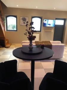 uma sala de estar com uma mesa e um sofá em Les Almadies private Jacuzzi em Villeneuve-les-Sablons