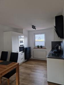 a kitchen with a table and a dining room at Ferienhaus Nordseeglück im Ferienpark Berumbur in Berumbur