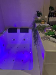 Habitación púrpura con bañera con luces moradas. en Les Almadies private Jacuzzi, en Villeneuve-les-Sablons