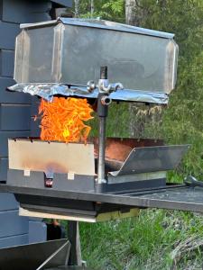 un fuego en una estufa de metal en Sauna cabin in the heart of Nuuksio National Park - Mökki Nuuksiossa, en Espoo