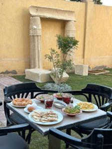 una mesa con platos de comida. en K Boutique Pyramids View West, en El Cairo