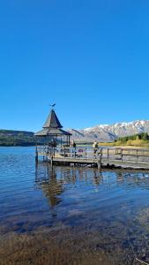 a dock with a gazebo on a lake at Hotel Sur Sur Patagónico in Esquel