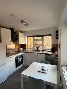 a kitchen with a white table and chairs in it at Stylish Ground Floor Apartment Nr Gloucester Docks, by Sauvignon Stays 