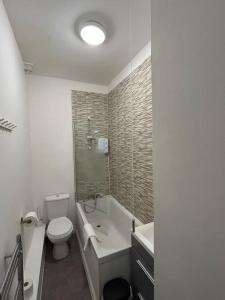 uma casa de banho com um WC, uma banheira e um lavatório. em Stylish Ground Floor Apartment Nr Gloucester Docks, by Sauvignon Stays 