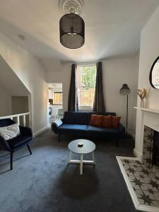 uma sala de estar com um sofá azul e uma lareira em Stylish Ground Floor Apartment Nr Gloucester Docks, by Sauvignon Stays 