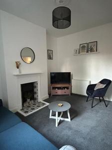 a living room with a couch and a table and a fireplace at Stylish Ground Floor Apartment Nr Gloucester Docks, by Sauvignon Stays 