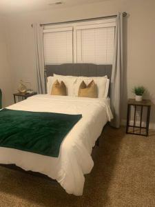 a bedroom with a large bed with green and white sheets at Welcome Home in Charlotte