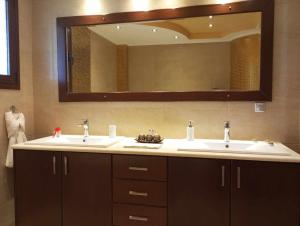 a bathroom with two sinks and a large mirror at Kos Villa - Family Comfort with large Garden, Jacuzzi in Kos +28 photos