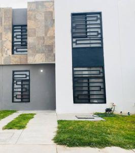 聖路易斯波托西的住宿－Cómoda Casa cerca de Soledad-Aeropuerto，两扇窗户的建筑