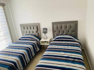 dos camas sentadas una al lado de la otra en un dormitorio en Cómoda Casa cerca de Soledad-Aeropuerto, en San Luis Potosí