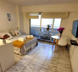una camera da letto con letto, tavolo e balcone di Nice Palermo a Buenos Aires