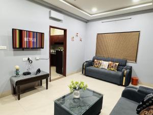 een woonkamer met een bank en een tafel bij Home Escape 2BHK Apartment Near Brilliant Convention Centre - Adults Only in Indore