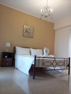 a bedroom with a large bed with a chandelier at Kos Villa - Family Comfort with large Garden, Jacuzzi in Kos