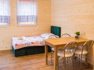ein kleines Zimmer mit einem Tisch und einem Bett in der Unterkunft Aura Zawady in Popów