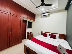 a bedroom with a large bed with red pillows at Home Escape 2BHK Apartment Near Brilliant Convention Centre in Indore