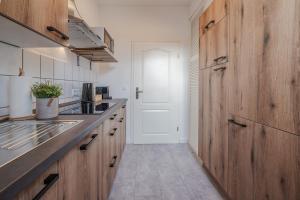 a kitchen with wooden cabinets and a large door at BENVILLE Freital - WLAN - Nespresso Kaffee - Windbergblick in Freital
