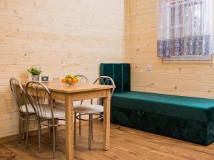 ein Esszimmer mit einem Tisch, Stühlen und einer Bank in der Unterkunft Aura Zawady in Popów