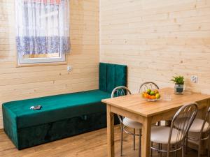 a room with a green bench and a table at Aura Zawady in Popów