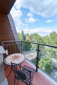 balcone con tavolo e sedie. di LAGUNA Willa Leśna 25 RETRO przy Parku Zdrojowym a Polanica-Zdrój