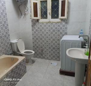 a bathroom with a toilet and a tub and a sink at Tut Amun in Abu Simbel