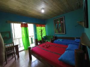 1 dormitorio con paredes azules y verdes y 1 cama en Reserva Natural Cañón Seacacar en Izabal