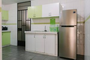 La cuisine est équipée d'un réfrigérateur en acier inoxydable et de placards blancs. dans l'établissement MODERNO DEPARTAMENTO CON 4 HABITACIONES, à Huancayo